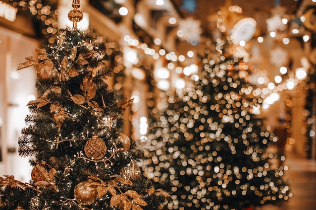 Árvores de Natal mágicas douradas decoradas com guirlandas milagrosas festivas bokeh luzes Interior mágico