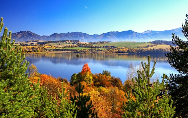 Árvores de outono e reflexo do espelho das montanhas no lago
