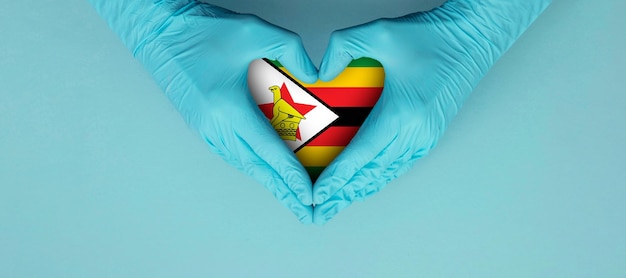 Ärzte tragen blaue OP-Handschuhe und machen ein Hörformsymbol mit Simbabwe-Flagge