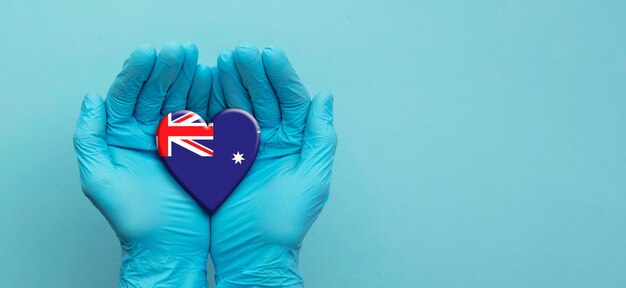 Ärzte tragen chirurgische Handschuhe, die das Herz der australischen Flagge halten