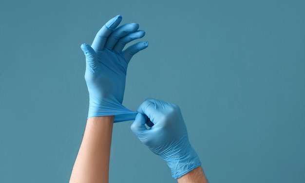 Ärzte tragen medizinische Handschuhe in Herzform auf blauem Hintergrund