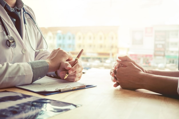 Ärzte und Patienten sitzen und sprechen mit dem Patienten über Medikamente