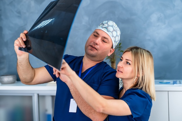 Ärzteteam bespricht die Diagnose des Röntgenbildes im Büro. Mediziner von Mann und Frau.