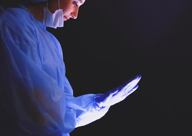 Ärzteteam in der Chirurgie vor dunklem Hintergrund