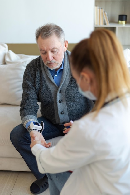 Ärztin älterer Mann misst seinen Blutdruck in der Arztpraxis oder zu Hause alter Mann Patient und d