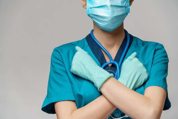 Ärztin der Krankenschwester mit Schutzmaske und Gummi- oder Latexhandschuhen - Stoppschildgeste