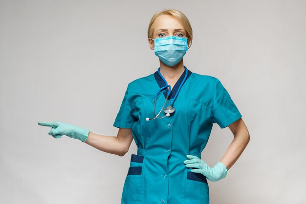 Ärztin der Krankenschwester mit Schutzmaske und Latexhandschuhen - zeigt auf virtueller Liste