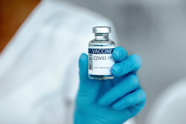 Ärztin, die COVID-19-Impfstoff in der Hand hält. Gesundheitswesen und medizinisches Konzept. COVID-19-Impfstoff in Forscherhänden, Konzept der Behandlung von Coronaviren,