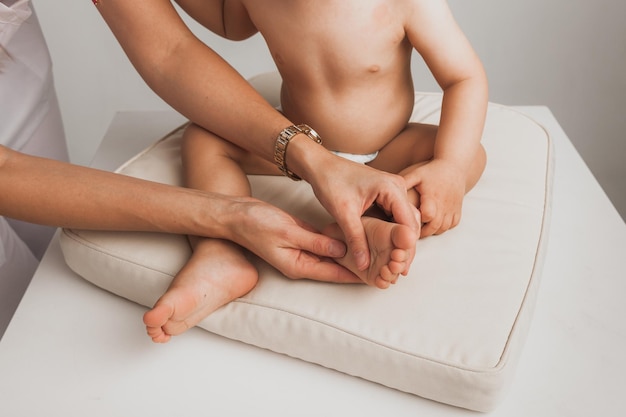 Ärztin, die einem einjährigen Baby Fußmassage macht. mütterliche Betreuung. gesunder Lebensstil.