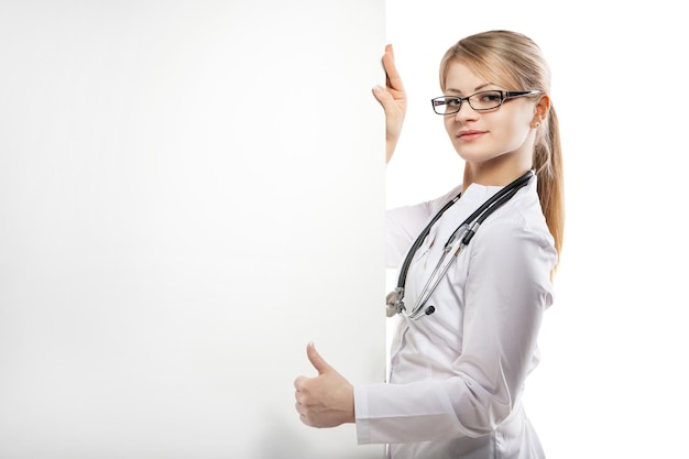 Ärztin Frau Lächeln mit Stethoskop halten leere Pappe zeigt Hand öffnen Palm Konzept Werbung Produkt leer Kopie Raum auf weißem Hintergrund