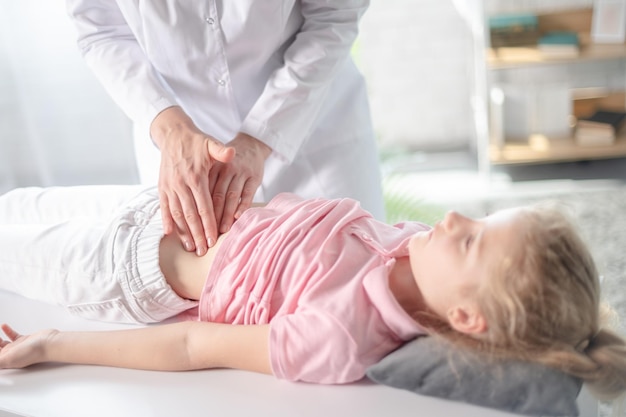 Ärztin im Krankenhaus oder in der Klinik untersucht den Magen junger Mädchen Gastroenterologie