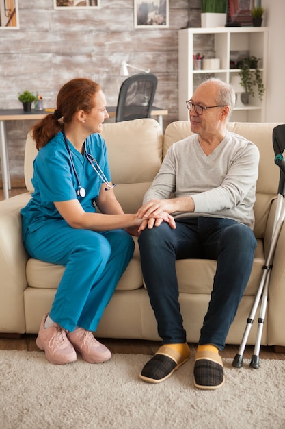 Ärztin im Pflegeheim im Gespräch mit männlichem Leiden von Alzheimer.