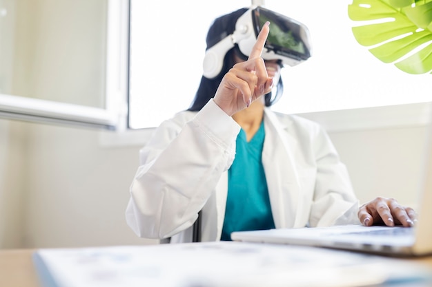 Ärztin in ihrem Büro, die eine Visionskonferenz mit einer Virtual-Reality-Brille macht