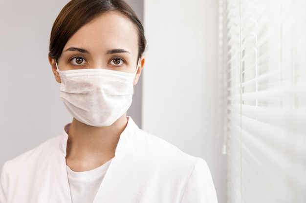 Ärztin in Maske am Fenster