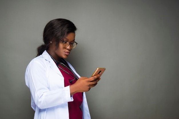Ärztin mit Handy über einem Studiohintergrund im Chat mit Freunden
