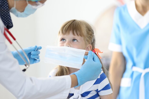 Ärztin mit kleinem Kind legte Schutzmaskenporträt auf