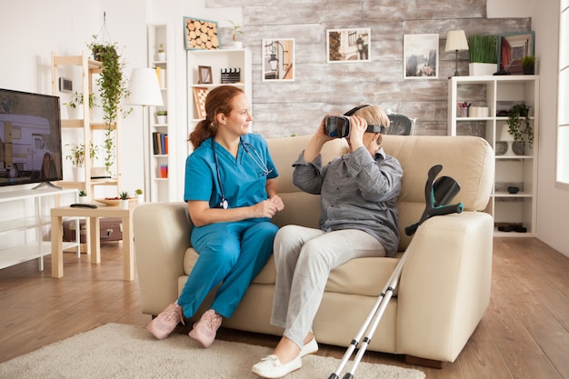 Ärztin mit Stethoskop und alter Frau mit vr-Kopfhörer.