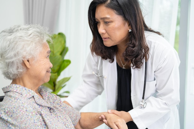 Ärztliche Hilfe und Pflege Asiatische Seniorin oder ältere Patientin der alten Dame, die im Rollstuhl auf der Krankenstation sitzt, gesundes, starkes medizinisches Konzept