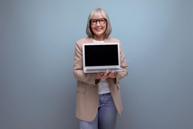 S mulher de jaqueta mostrando maquete de tela de laptop em fundo brilhante com espaço de cópia