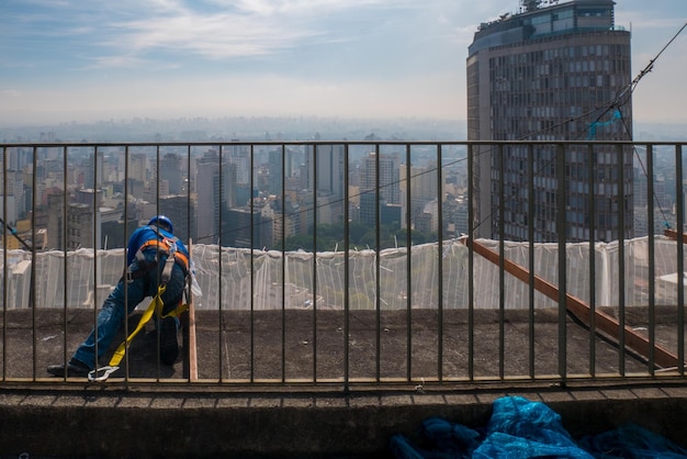 SÃO PAULO BRASIL 13 DE SETEMBRO DE 2017 trabalhador fazendo reparos em cima do prédio antigo