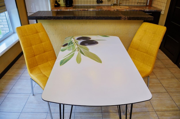 SÃO PETERSBURGO, RÚSSIA - 17 DE SETEMBRO DE 2021: Interior de uma cozinha confortável e moderna. Cadeiras amarelas e uma mesa de cozinha.