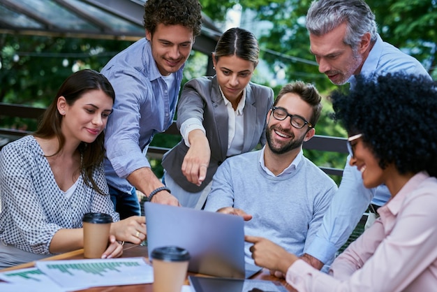 Às vezes o sucesso acontece fora do escritório Foto recortada de um grupo de colegas de negócios tendo uma reunião ao ar livre em um café