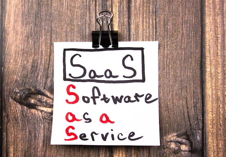 Foto saassoftware as a service texto en una hoja sobre la mesa concepto saas