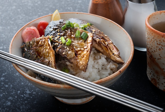 Saba parrilla de pescado con salsa teriyaki sobre arroz.