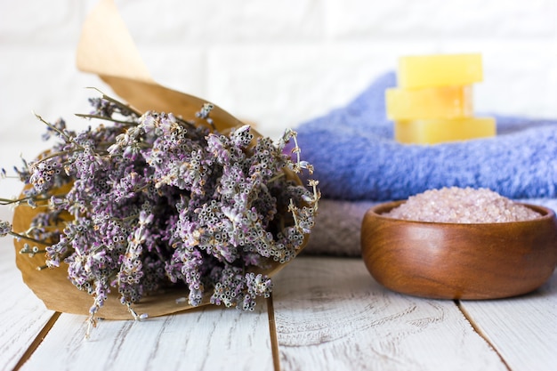 Sabão de lavanda natural e sal de banho, óleo francês e toalhas em um fundo branco de madeira