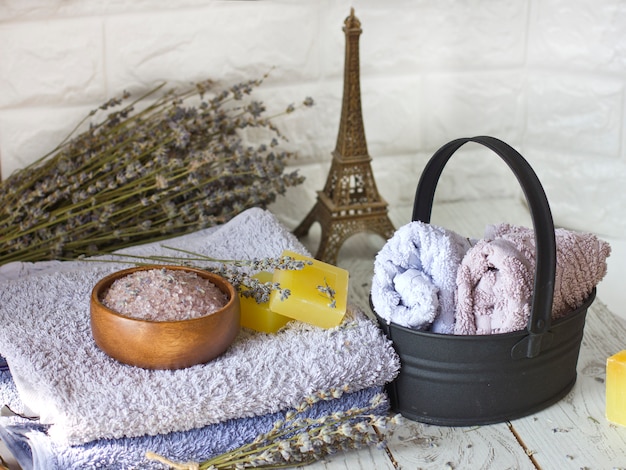Sabão de lavanda natural e sal de banho, óleo francês e toalhas em um fundo branco de madeira
