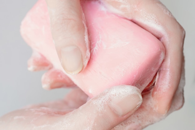 Sabão em close-up. Sabão antibacteriano nas mãos. Desinfecção das mãos com sabão. Limpeza e higiene na vida cotidiana. Higiene das mãos
