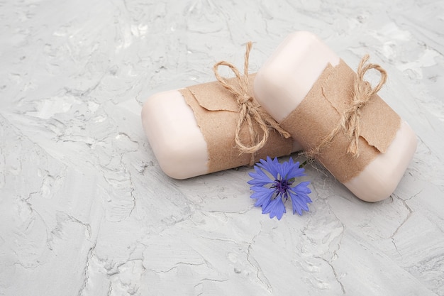 Foto sabão natural artesanal decorado com papel artesanal, flagelo e flores azuis.