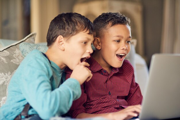Foto ¿sabe lo que sus hijos miran en línea? una foto de dos niños que se ven asombrados por algo en internet.