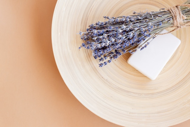 Sabonete artesanal de lavanda. barra de sabonete natural com flores de lavanda secas na placa de bambu com espaço de cópia. Cosméticos orgânicos para cuidados com a pele e spa.