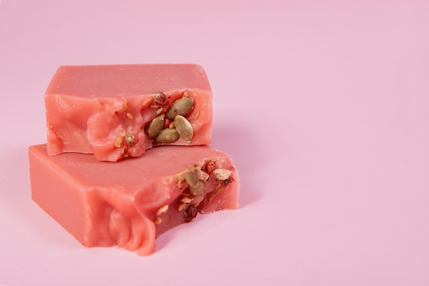 Sabonete caseiro feito à mão em um fundo rosa. sabor cidra cereja. pequenos negócios, produtos orgânicos, ingredientes naturais. vista do topo.
