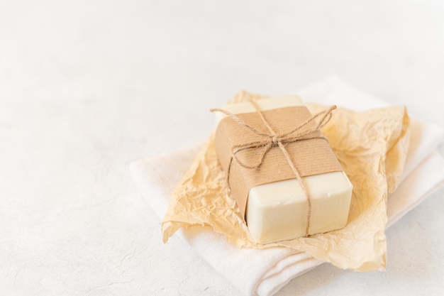 Saboneteira de madeira, papel ofício, tecido de algodão, sabonete, sobre fundo branco.