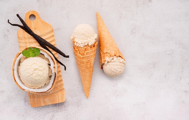 Sabores de sorvete de coco na metade da configuração de coco em fundo de pedra branca. Conceito de menu de verão e doce.