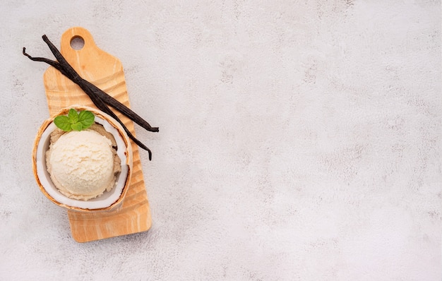 Sabores de helado de coco en la mitad de la configuración de coco sobre fondo de piedra blanca. Concepto de menú de verano y dulces.