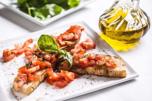 Saborosa bruscheta de aperitivo italiana no prato com azeite.