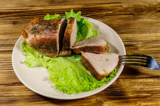 Saborosa carne de porco assada com especiarias em uma mesa de madeira