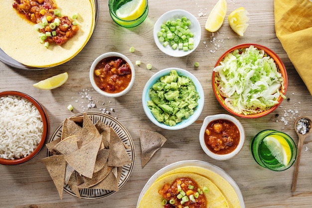 Saborosa comida mexicana com molho de abacate fresco burittos tacos chili com carne na mesa de madeira