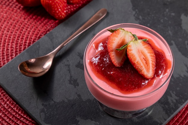 Saborosa mousse de morango em copo com geléia por cima.