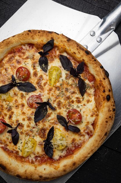 saborosa pizza com queijo e legumes em uma mesa de madeira escura