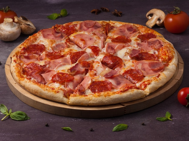 Saborosa pizza de carne com presunto, bacon e calabresa em uma placa de madeira