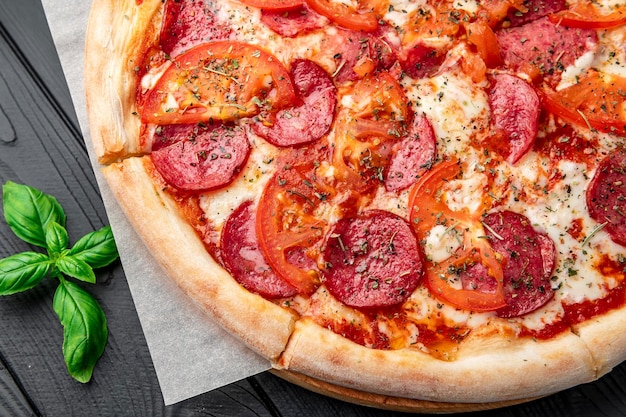 Saborosa pizza e ingredientes de cozinha tomates manjericão