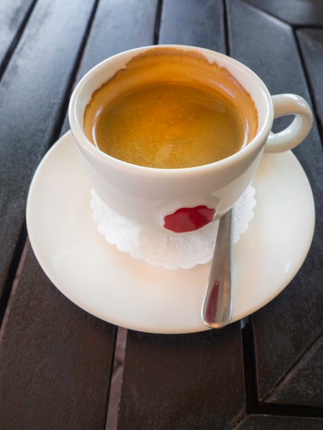 Saborosa xícara branca de cappuccino com latte art na mesa de madeira