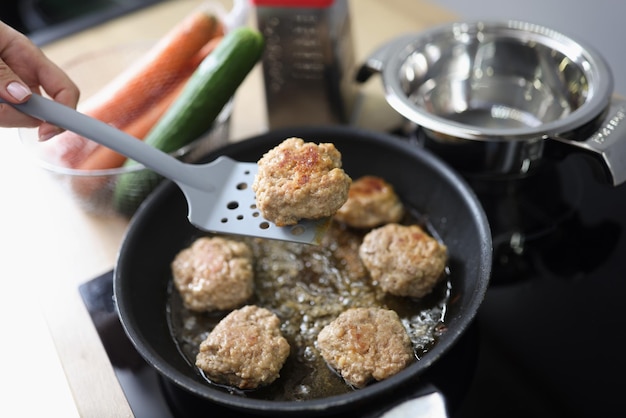 Saborosas almôndegas aromáticas fritando em óleo na frigideira no fogão da cozinha