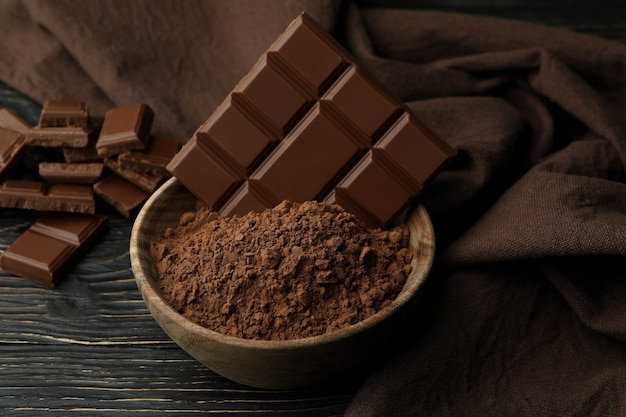 Saborosas barras de chocolate em pó na mesa de madeira