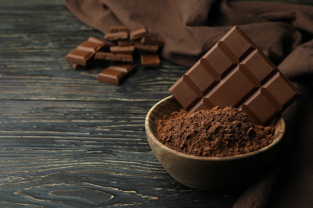 Saborosas barras de chocolate em pó na mesa de madeira