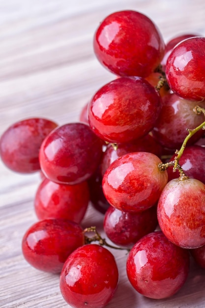 Saborosas e frescas uvas vermelhas em uma mesa de madeira